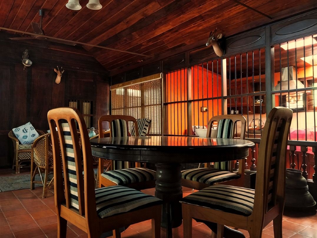 Dining room with round wooden table and carved chairs