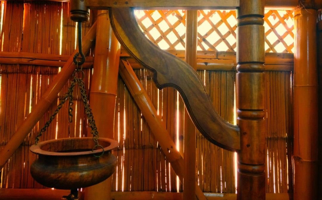 Traditional carved wooden detail and hanging brass vessel